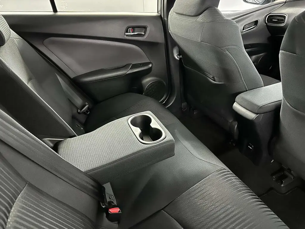 Rear seats of economy class vehicle with fold-down centre armrest and cupholders