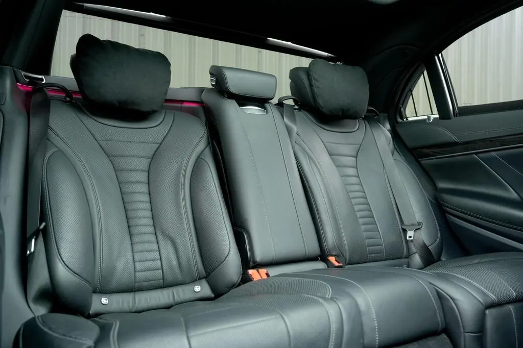 Black leather rear seats with cushioned headrests in premium chauffeur-driven car